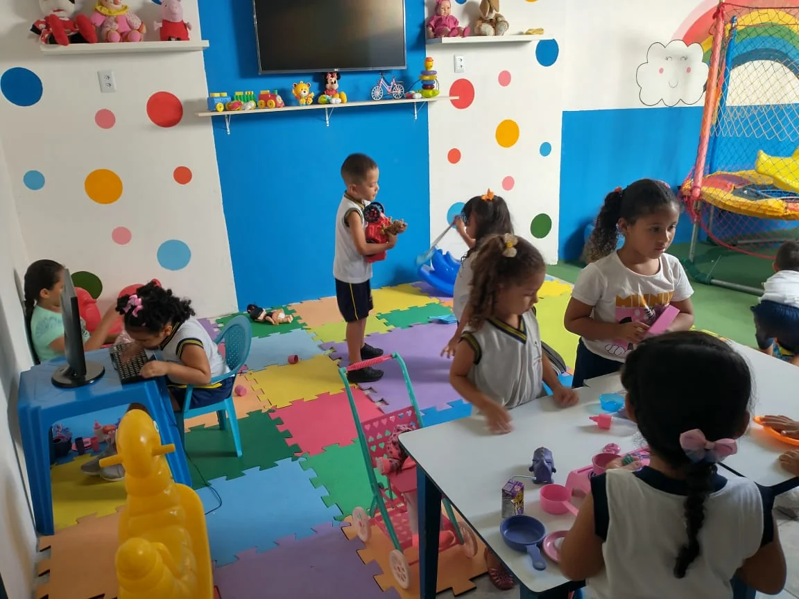 Sala de aula da Educar Kids com mesas infantis e um mural colorido